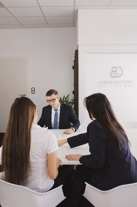 Das Team von Immobilien Christian Borch in einer Besprechung am Schreibtisch
